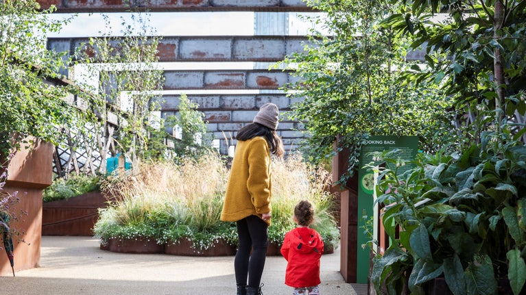 A parent and child wearing colourful coats explore Castlefield Viaduct.